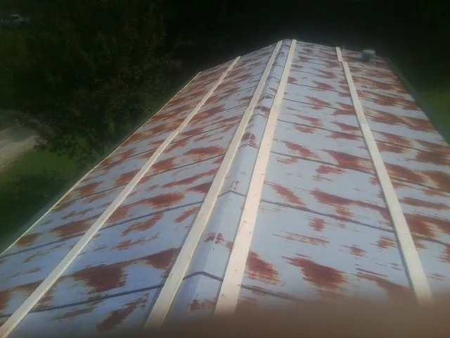 Rusted metal roof panels with new wood purlins before replacement — Storm Damage Roof Repair in Appalachia by Roofing Brothers